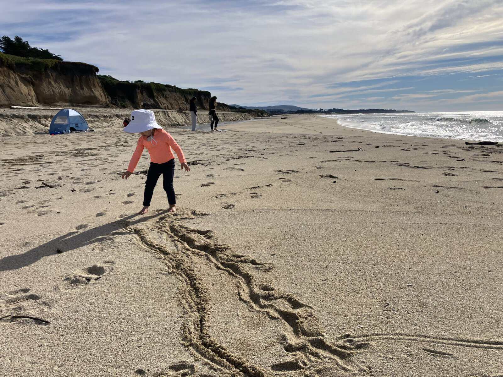A little girl plays on the beach
