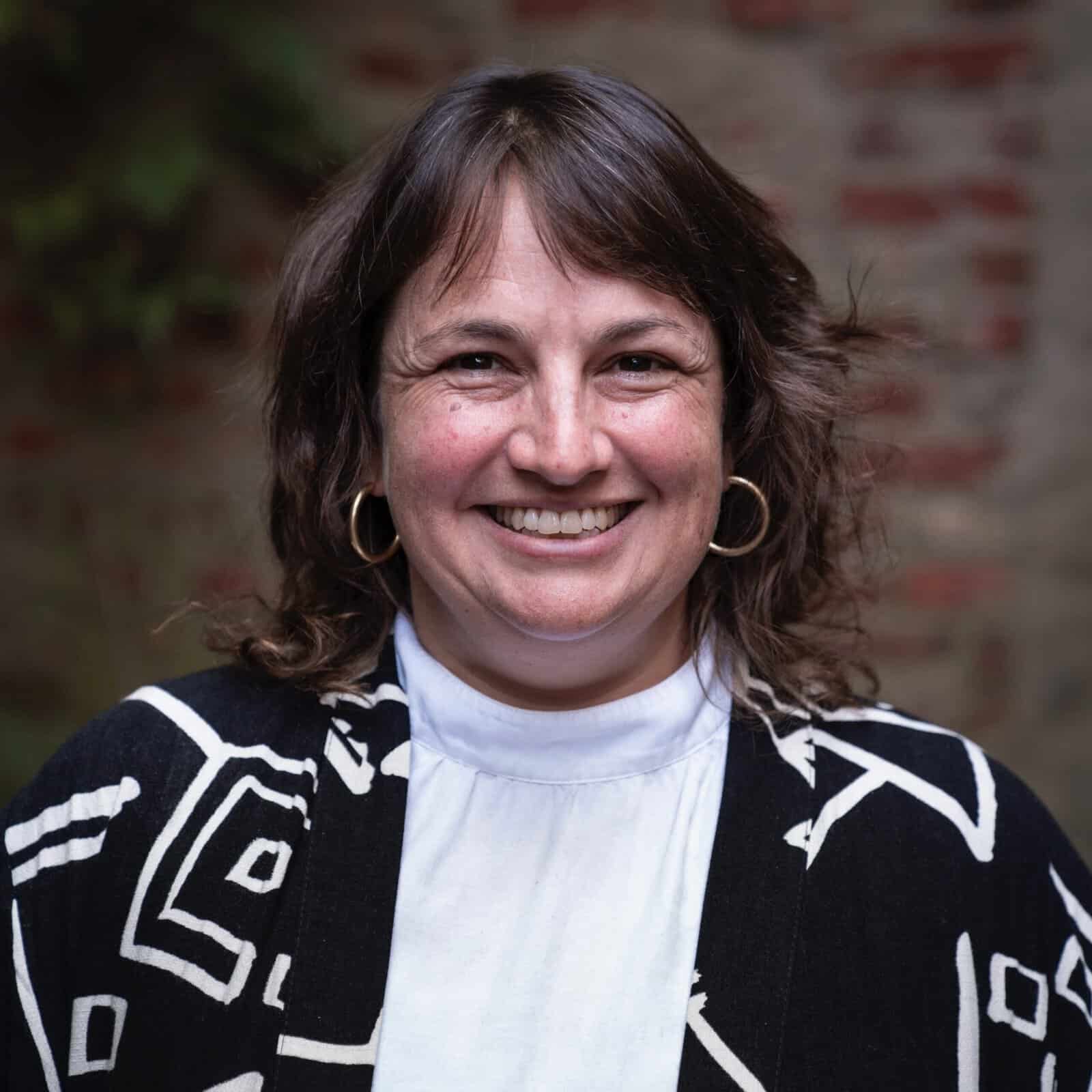 a woman smiles in professional attire
