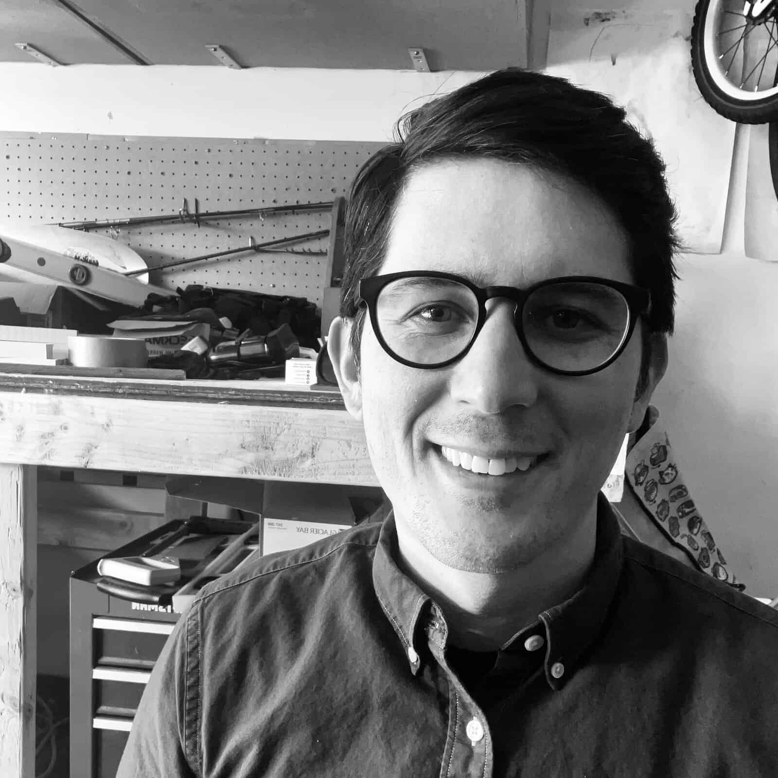 A man in glasses in a workshop.
