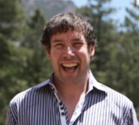 a man smiles outside