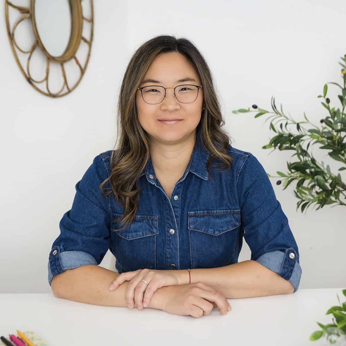 a woman with glasses smiles